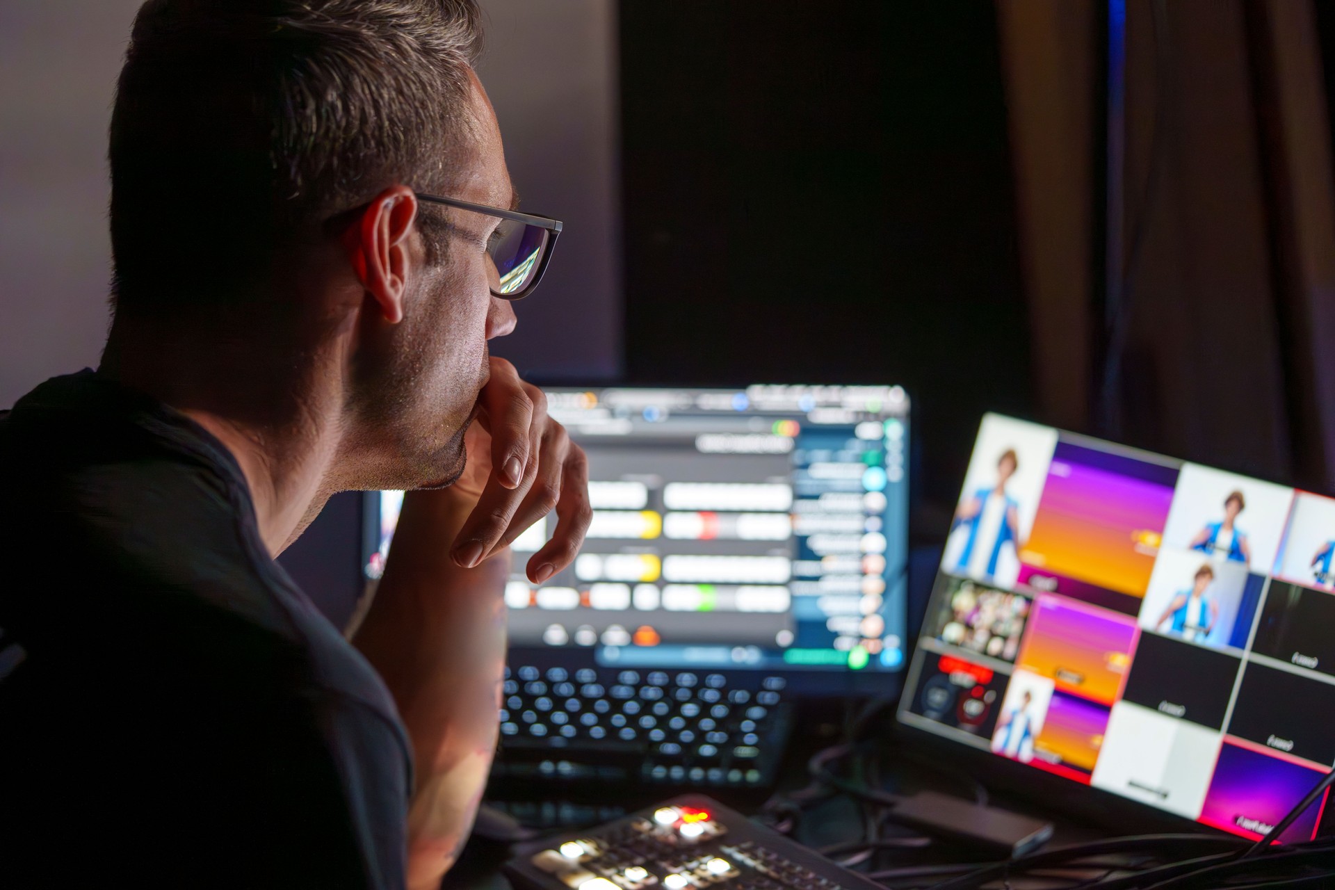 Video Director Managing Multiple Screens and Equipment in a Control Room During a Live Broadcast